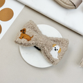 Mocha brown teddy bow tie with embroidered dogs by Cocopup London, displayed on a round white dish.