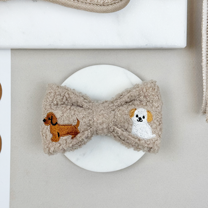 Mocha Teddy Bow Tie with brown and white dog pattern by Cocopup London, displayed on a round white surface.