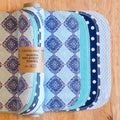 Set of reusable non-paper towels with patterned designs on a wooden surface