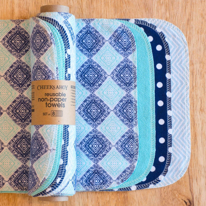 Set of reusable non-paper towels with patterned designs on a wooden surface