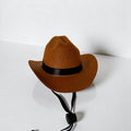 Brown dog cowboy hat with black band and adjustable chin strap, displayed on a plain white surface.