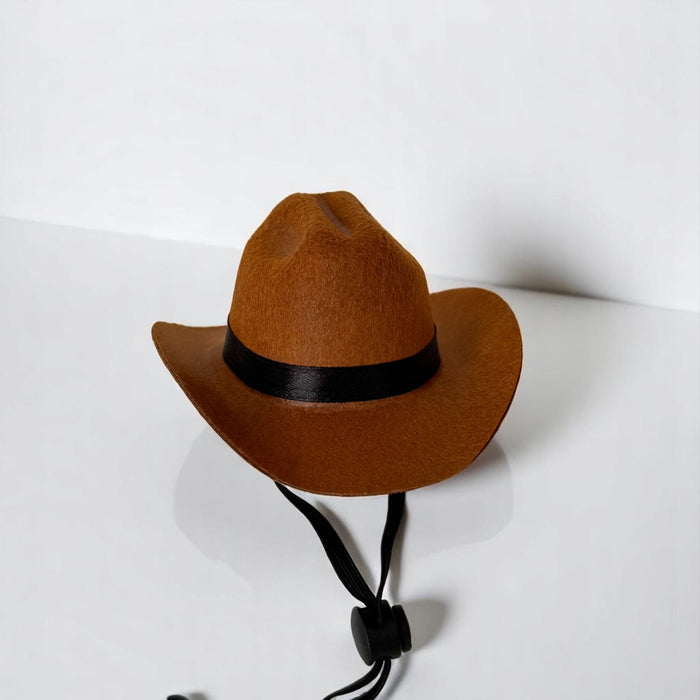 Brown dog cowboy hat with black band and adjustable chin strap, displayed on a plain white surface.