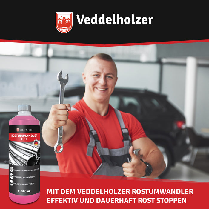 Lachender Mechaniker in roter Latzhose hält in der Werkstatt einen Gabelschlüssel hoch, links im Bild die Gelflasche