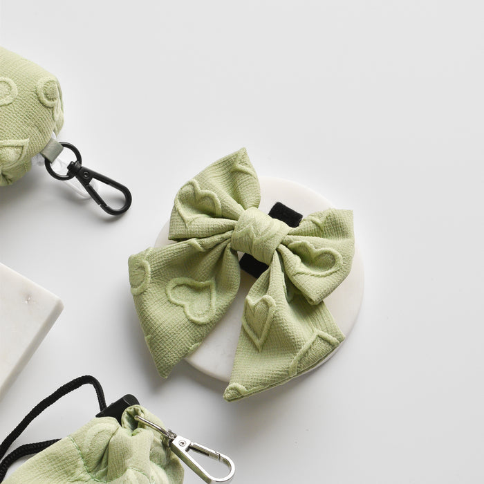 Sage green sailor bow tie with white heart pattern and matching clip accessories on a white surface.