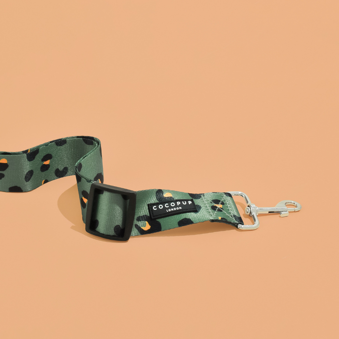Khaki leopard print seat belt restraint from Cocopup London on a peach background.