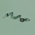 Khaki Cocopup London seat belt restraint with metal clips, displayed on a matching khaki background.