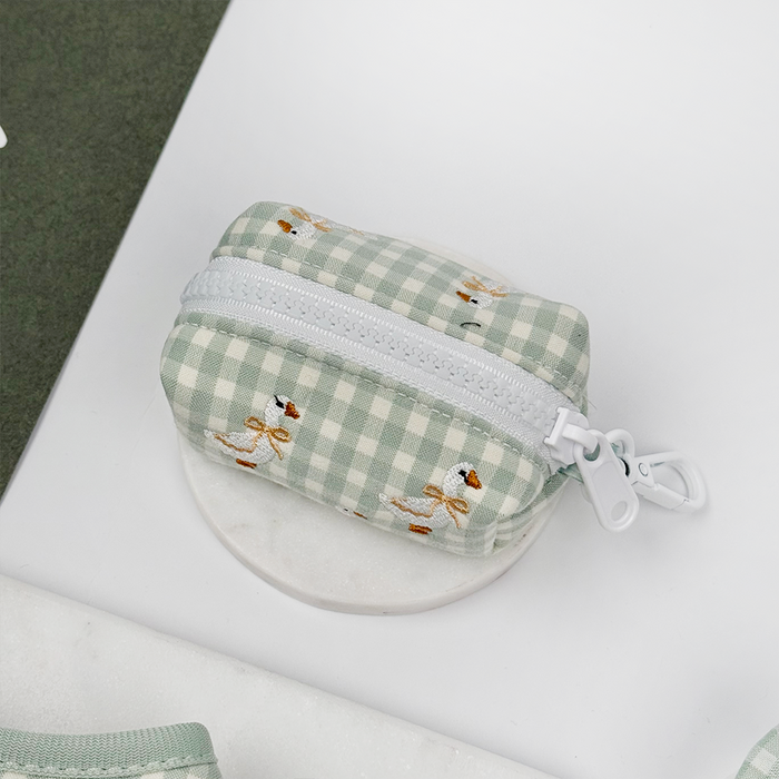 Green and white check print poop bag holder with embroidered geese design.