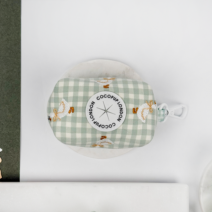 Green and white check print poop bag holder with dispenser with embroidered geese design.