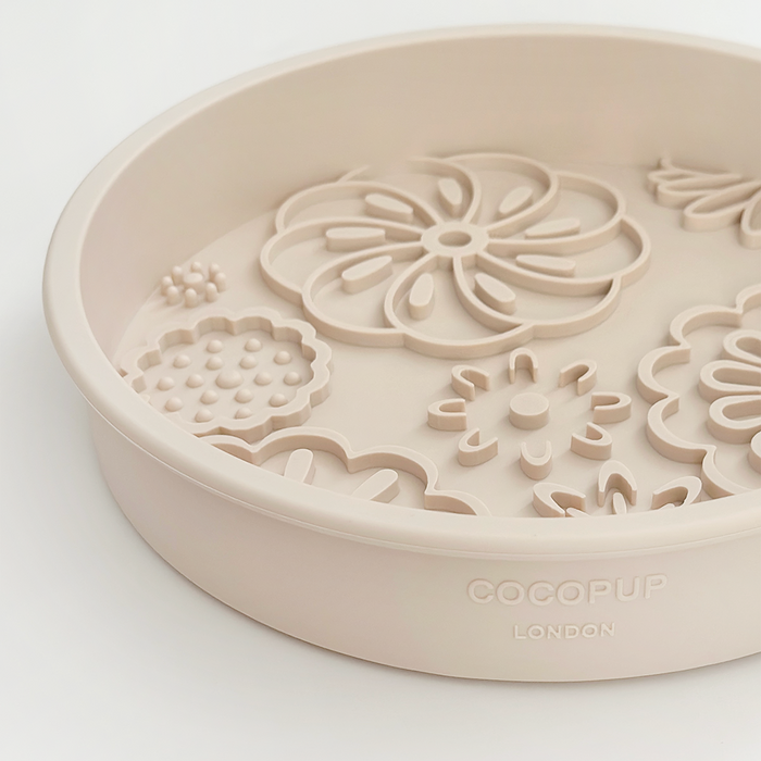 Baby pink silicone slow feeder dog bowl with raised flower patterns, Cocopup London branding.