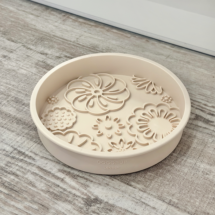 Baby pink floral slow feeder dog bowl by Cocopup London on a wooden surface.