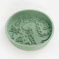 Sage green silicone dog slow feeder bowl with raised dinosaur pattern by Cocopup London.
