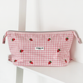 Expandable pink gingham makeup bag with strawberry embroidery and Cocopup London branding.