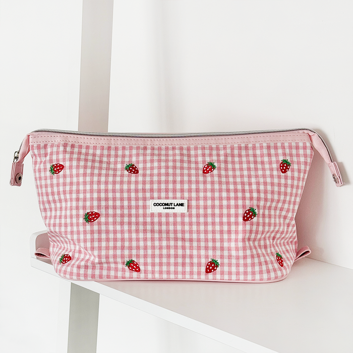 Expandable pink gingham makeup bag with strawberry embroidery and Cocopup London branding.
