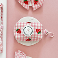 Strawberry-print Cocopup London poop bag holder on a pink and white background.