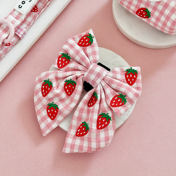 Dog bow tie with pink check pattern and red strawberry accents from Cocopup London.