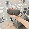 Grey dog walking bag with leopard strap held in hand, shown beside a matching bag and mocha sunglasses case.