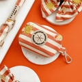 A orange and beige stripe poop bag holder, to hold dog poo bags, with embroidered drink and sun graphics.