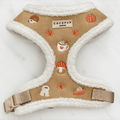 Brown dog harness with white sherpa trim and autumnal-themed embroidery of pumpkins, leaves, a coffee cup, and mushrooms.