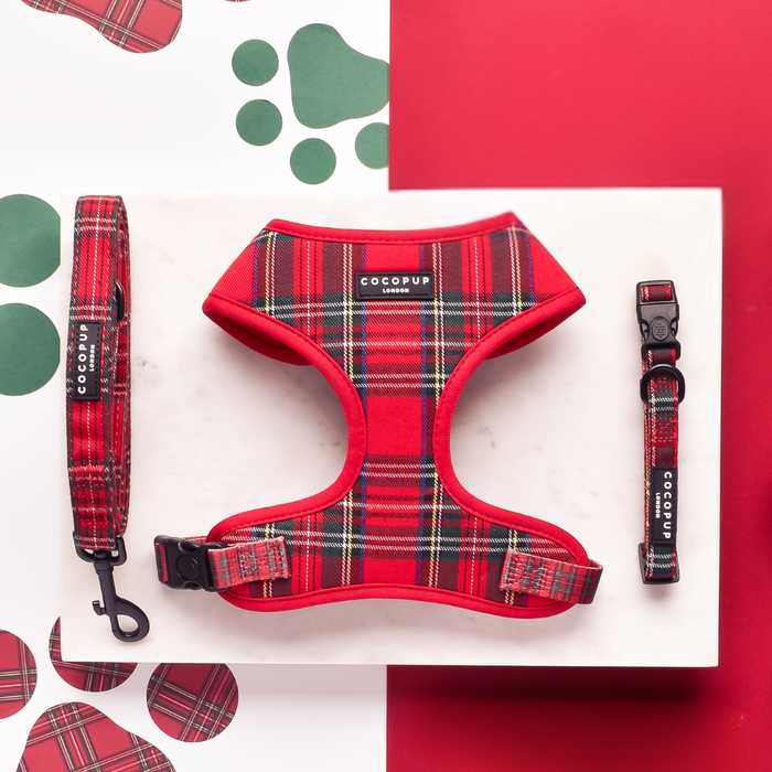 Tartan-patterned Cocopup London harness, lead, and collar set displayed on marble with red and white paw print background.
