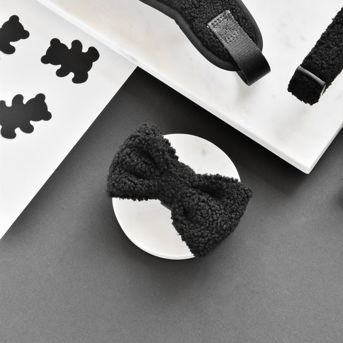 Brown teddy bear print bow tie on a round dish with teddy stickers, set against a gray and white background.