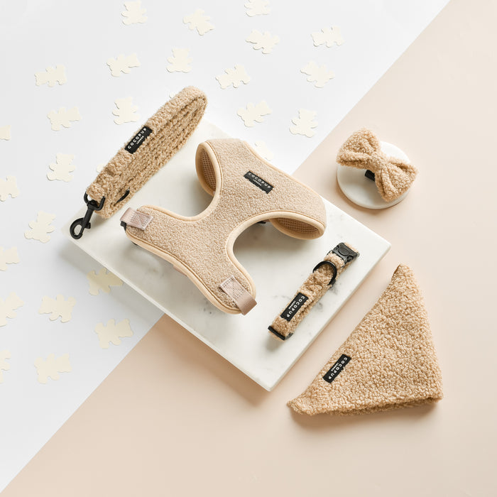 Set of teddy bear-textured dog accessories in tan: harness, leash, collar, bandana, and Cocopup London bow tie.