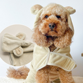 Curly-haired dog in beige Cocopup London Teddy Drying Robe with bear ears, showing close-up of velcro closure.