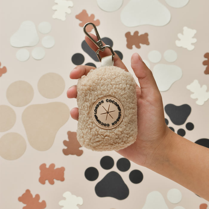 Fluffy beige Teddy Poop Bag Holder by Cocopup London with metal clip attachment.