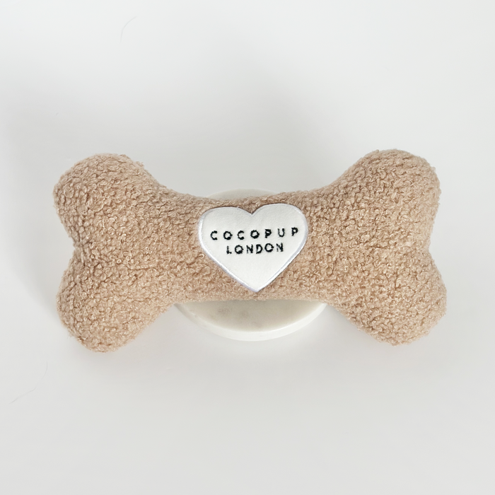Beige bone-shaped dog toy with a heart patch, Teddy Rupert by Cocopup London.