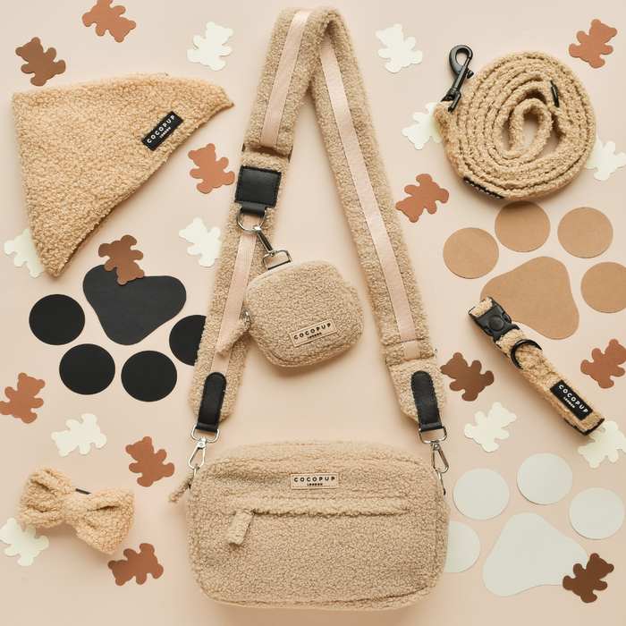 Tan Cocopup Teddy Rupert dog walking bag set with leash, harness, and treat pouch on a beige cutout-patterned background.
