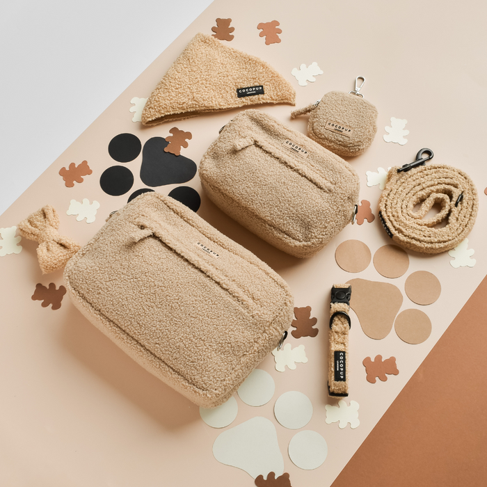 Cocopup London Teddy Rupert beige dog walking bag with treat pouch and accessories on a beige surface with bear cutouts.