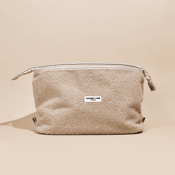 Beige textured expandable makeup bag with a white COCONUT LANE label on the front.