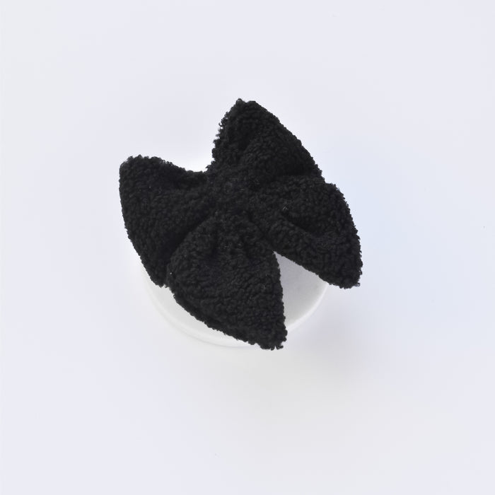 Black Teddy Sailor Bow Tie pet hair clip by Cocopup London, displayed on a plain white circular background.