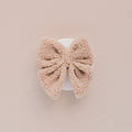 Brown Teddy fleece sailor bow tie displayed on a white circle, with a light beige background.