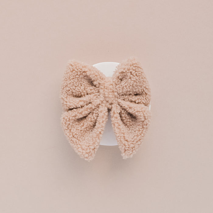 Brown Teddy fleece sailor bow tie displayed on a white circle, with a light beige background.
