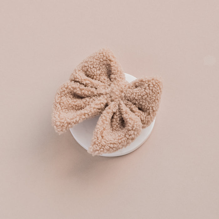 Cream Teddy Sailor Bow Tie by Cocopup London displayed on a round white platform with a light beige background.