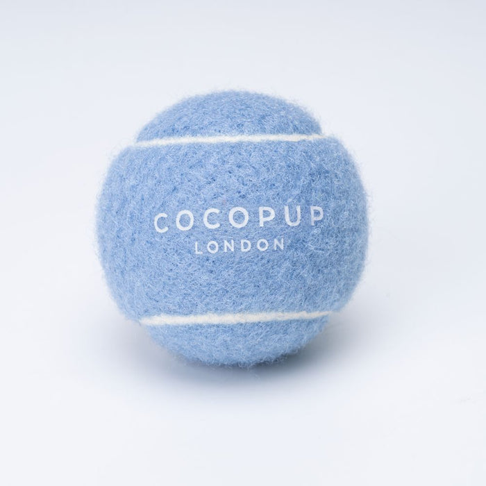 Light blue tennis ball dog toy with white stripes and COCOPUP LONDON branding.