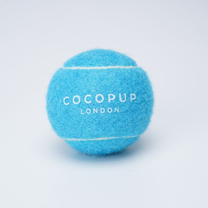 Bright blue Cocopup London tennis ball dog toy on a plain white background.