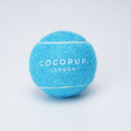 Bright blue Cocopup London tennis ball dog toy on a plain white background.