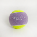 Lilac and yellow Cocopup London tennis ball dog toy on a white background.