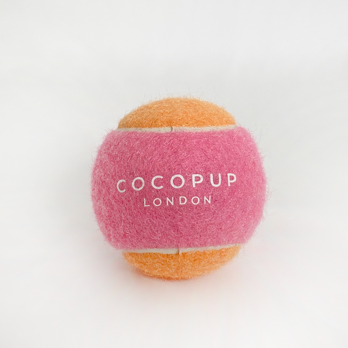 Pink and orange Cocopup London tennis ball fetch toy with logo on a white background.
