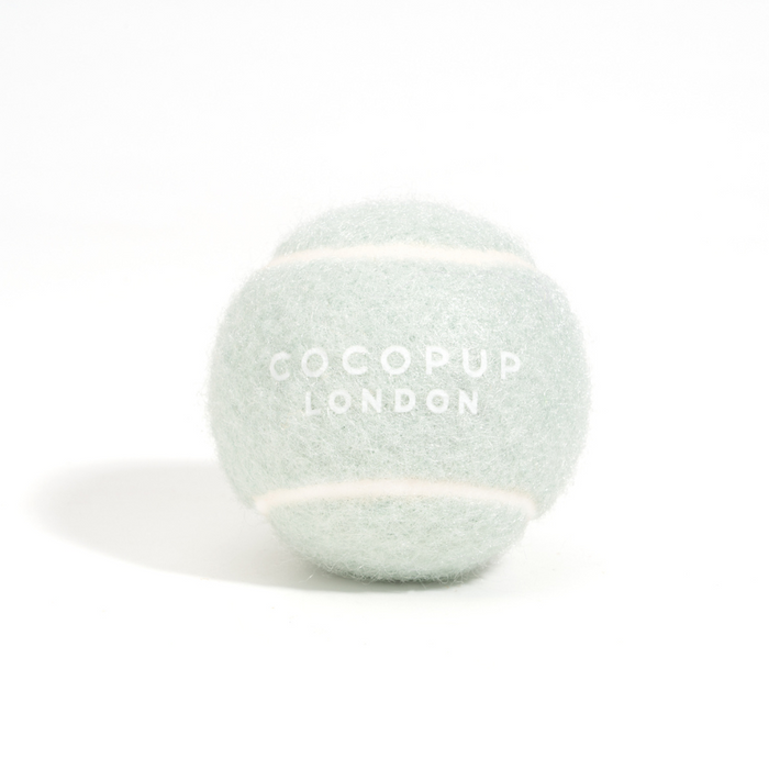 Light green Cocopup London tennis ball with brand logo, shown on a plain white background.