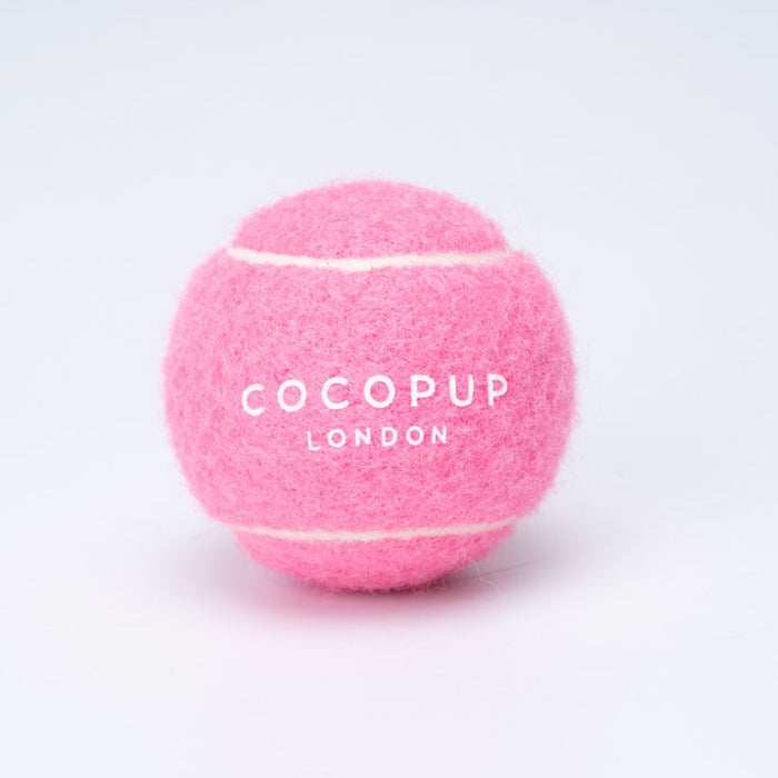Pink Cocopup London tennis ball with branded text on a plain white background.