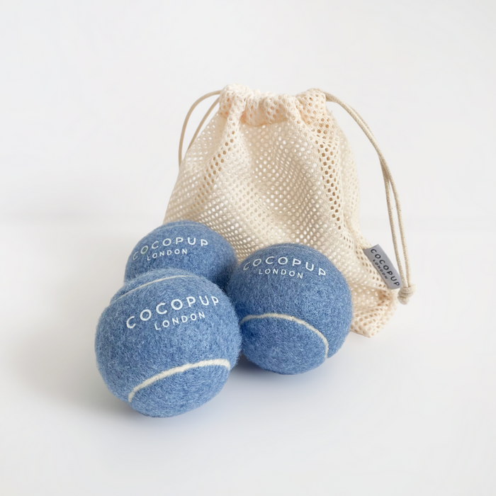Set of 3 blue tennis balls and a mesh bag, Cocopup London branding visible on the balls.