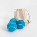 Set of three bright blue Cocopup London tennis balls inside a see-through mesh drawstring bag.