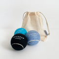 Set of three Cocopup London tennis balls in black, light blue, and bright blue with a beige mesh carry bag.