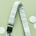 Cocopup London mocha dog walking bag with white lanyard and black clip on a pale green background.