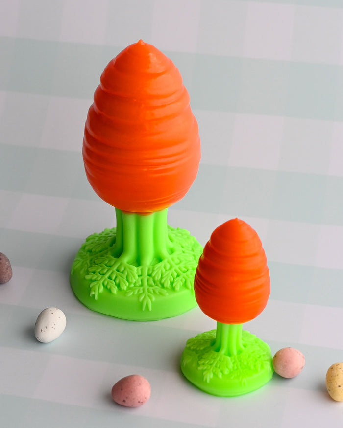 Two orange and green carrot-shaped toys on a checkered background