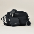 Black Cocopup London dog walking bag set with treat pouch, logo patch, and a round keychain.