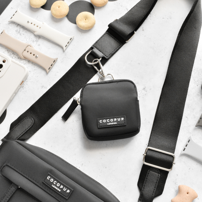 Black Cocopup London dog walking bag bundle with matching straps, watch bands, pouch, and dog treats arranged flat.