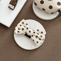 Polka dot bow Tie on a marble surface with a brown background